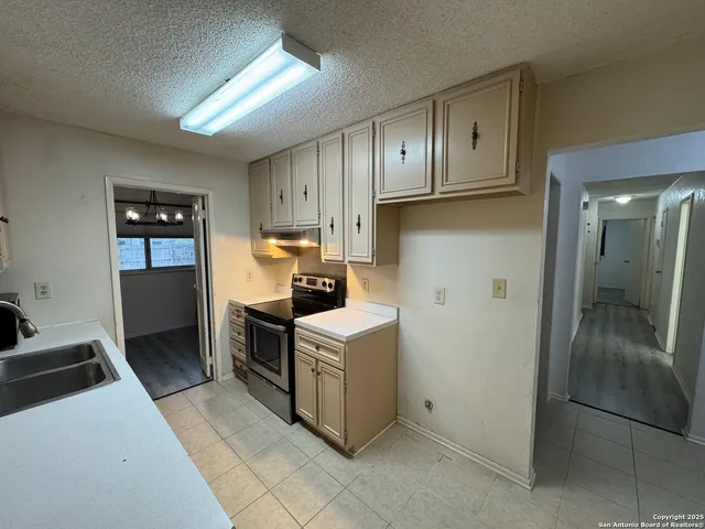 a kitchen with a stove sink and a refrigerator