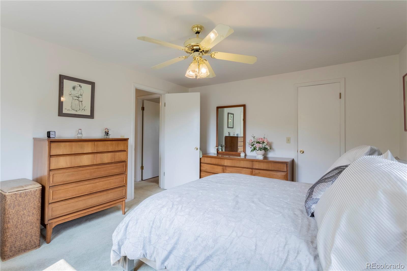 6001 Welch Street Arvada, CO 80004 - Photo 15 of 32 a bedroom with a bed and a chandelier