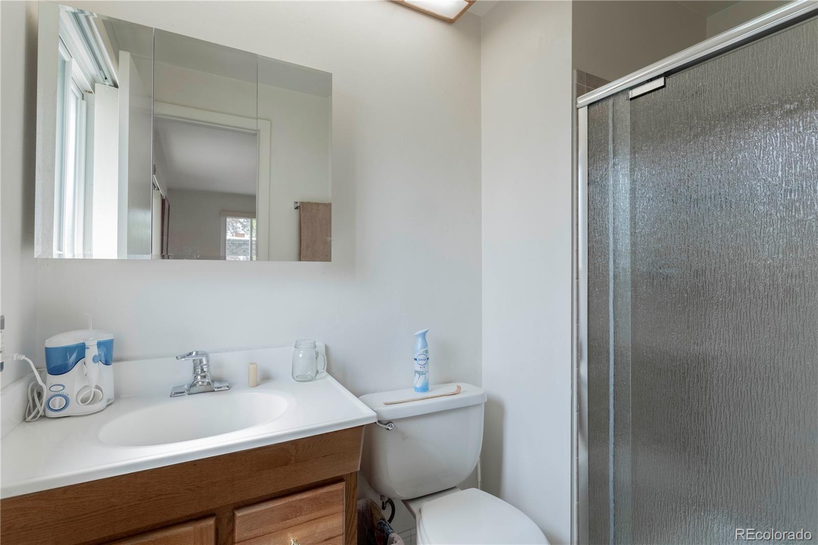 6001 Welch Street Arvada, CO 80004 - Photo 16 of 32 a bathroom with a sink vanity mirror and toilet