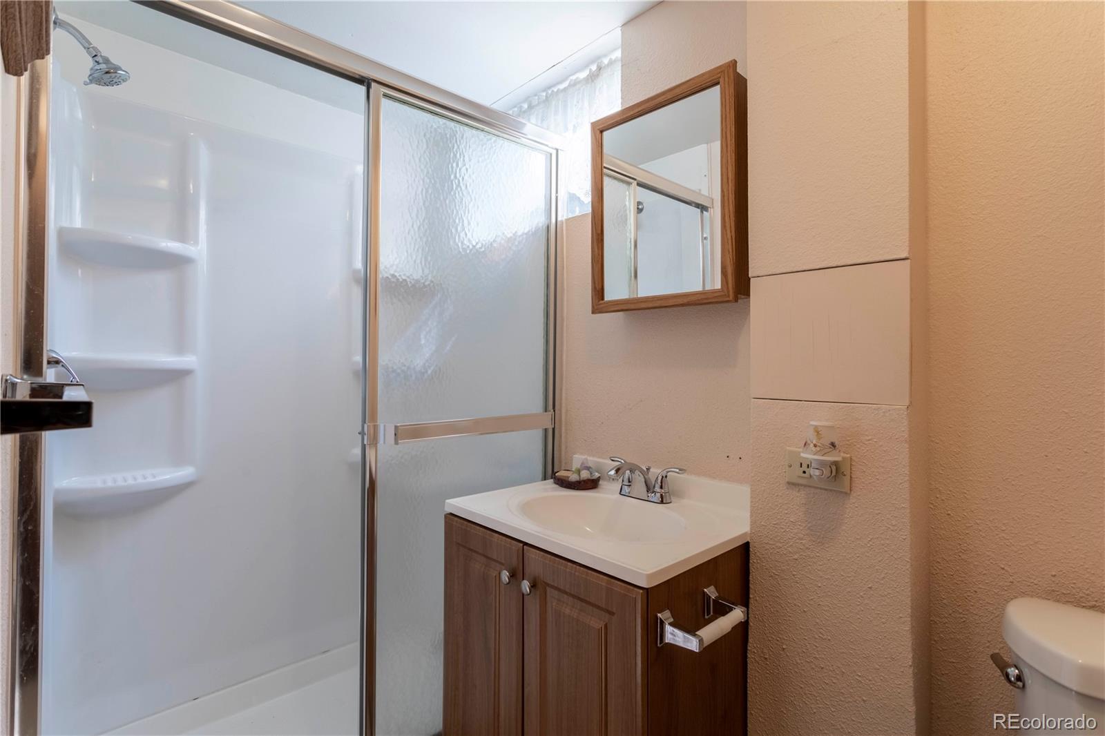 6001 Welch Street Arvada, CO 80004 - Photo 22 of 32 a bathroom with a sink and a mirror