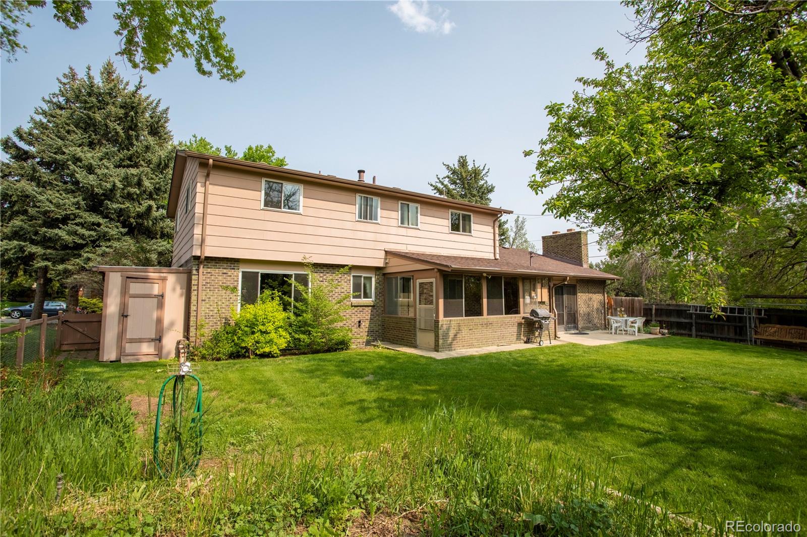 6001 Welch Street Arvada, CO 80004 - Photo 24 of 32 a front view of a house with a yard and trees