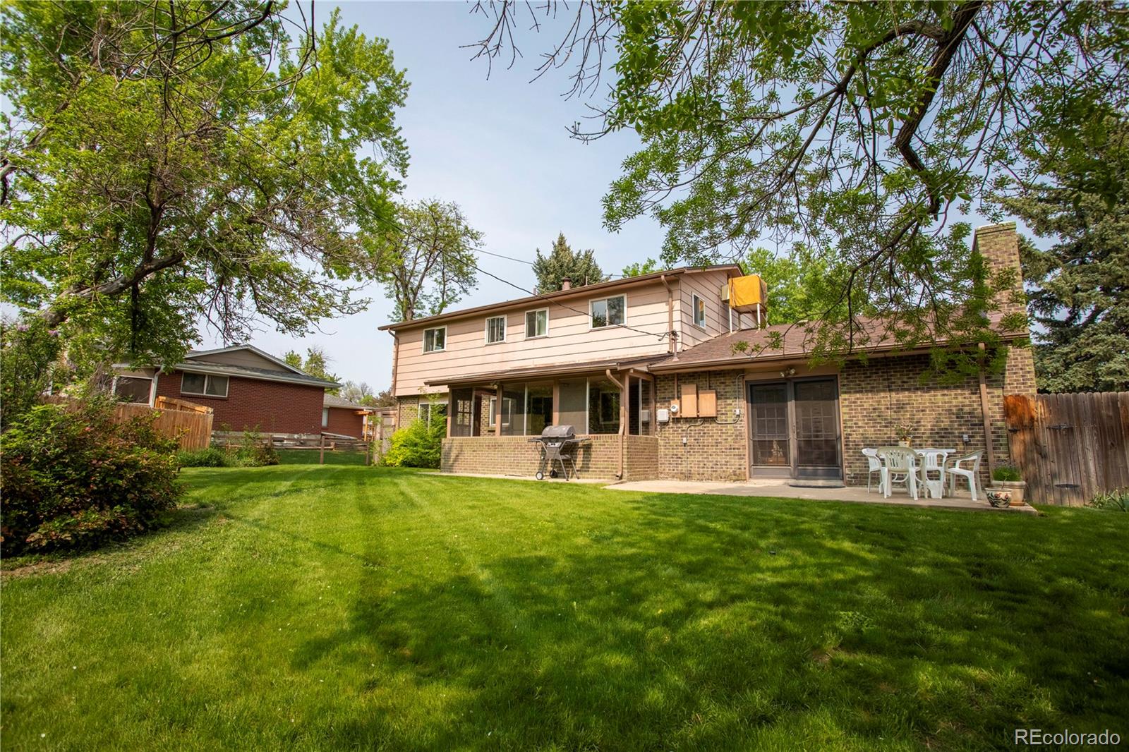 6001 Welch Street Arvada, CO 80004 - Photo 26 of 32 a view of a house with a big yard and large trees
