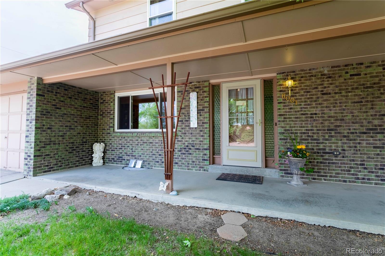 6001 Welch Street Arvada, CO 80004 - Photo 4 of 32 a front view of a house with a porch