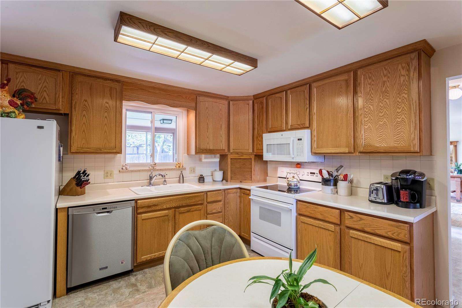 6001 Welch Street Arvada, CO 80004 - Photo 8 of 32 a kitchen with a sink a stove cabinets and counter space