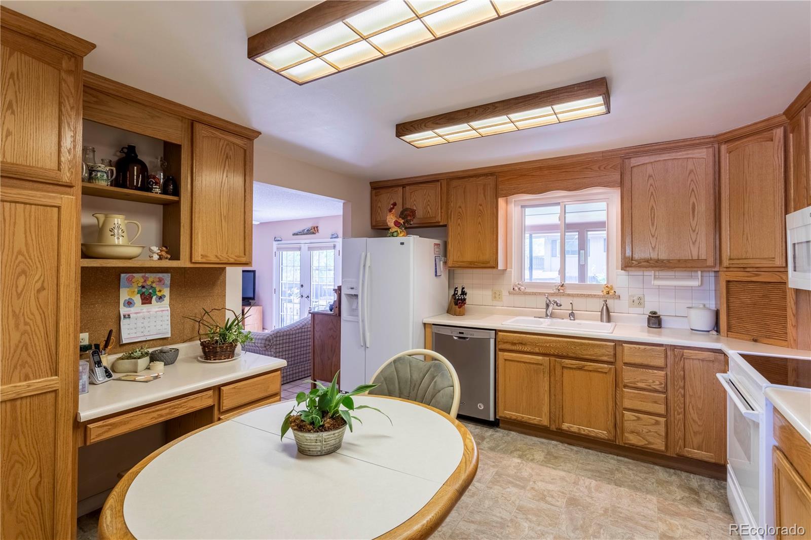 6001 Welch Street Arvada, CO 80004 - Photo 9 of 32 a kitchen with stainless steel appliances granite countertop a sink a stove and a refrigerator