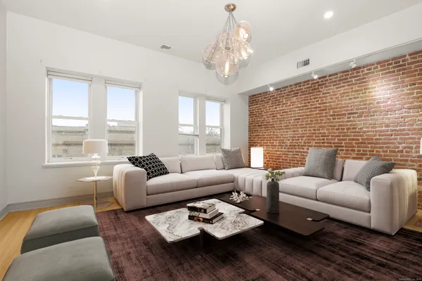a living room with furniture chandelier and a window