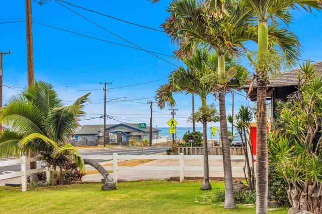 a view of a swimming pool with a lawn chairs and palm trees