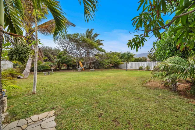 a backyard of a house with table and wooden fence