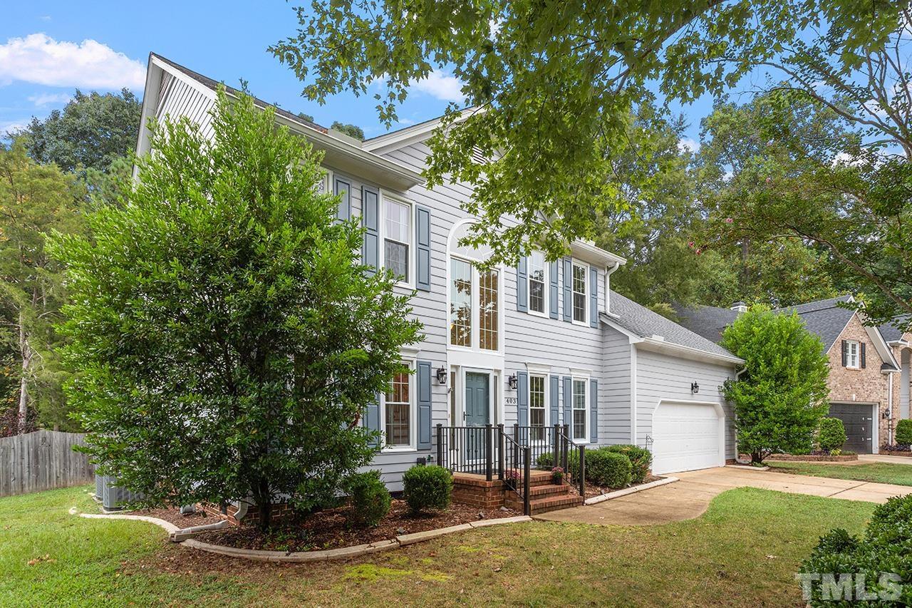 403 Danton Drive Cary, NC 27518 - Photo 2 of 38 a view of a white house next to a yard with plants and trees