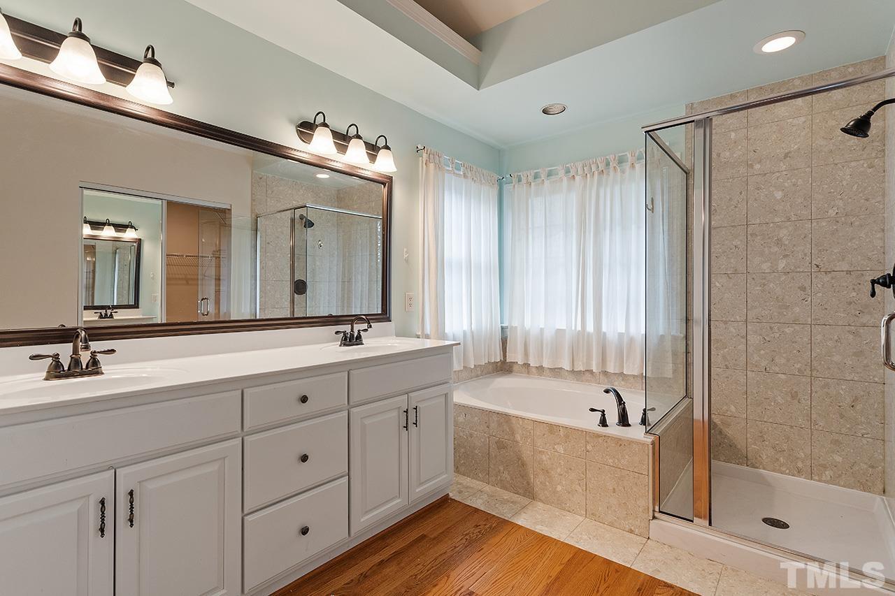 403 Danton Drive Cary, NC 27518 - Photo 25 of 38 a bathroom with a double vanity sink mirror and bathtub