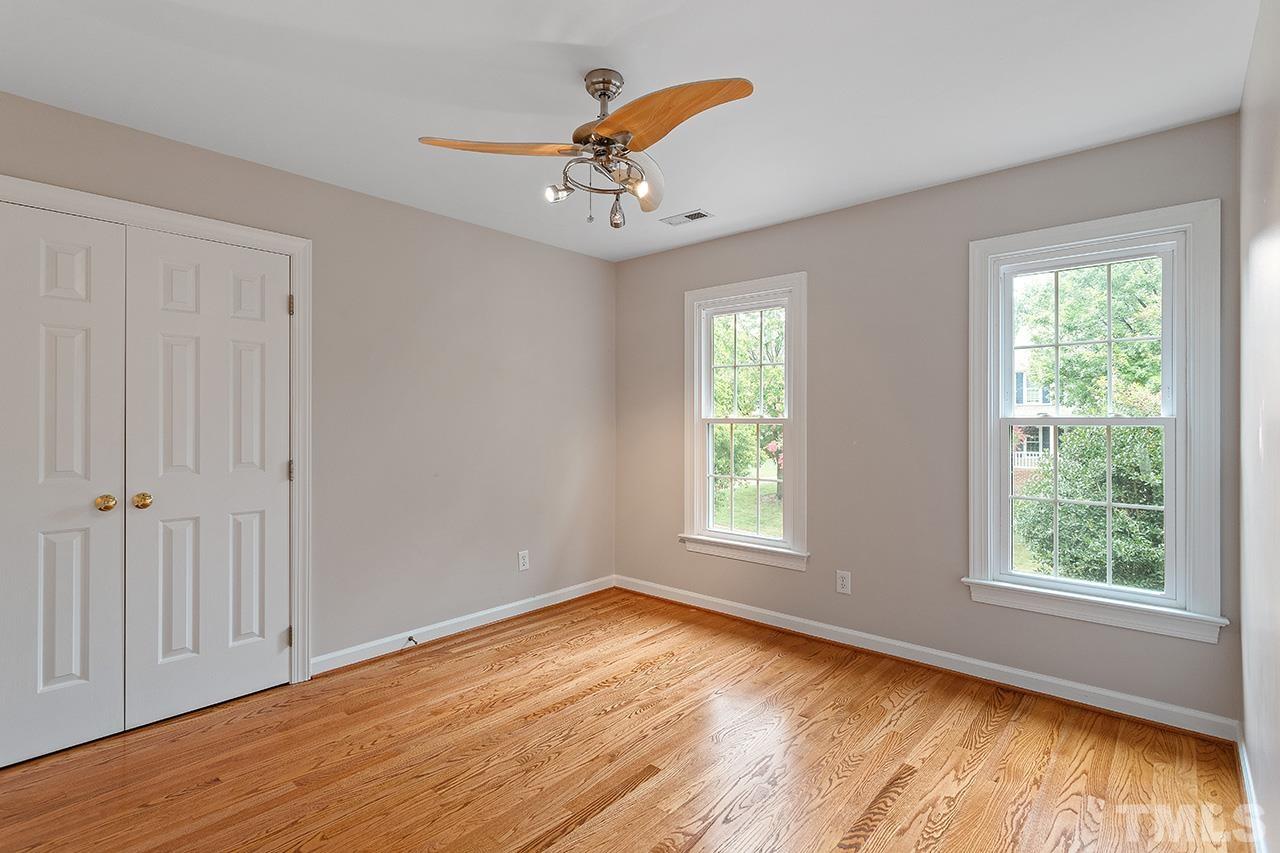 403 Danton Drive Cary, NC 27518 - Photo 27 of 38 an empty room with wooden floor chandelier fan and windows