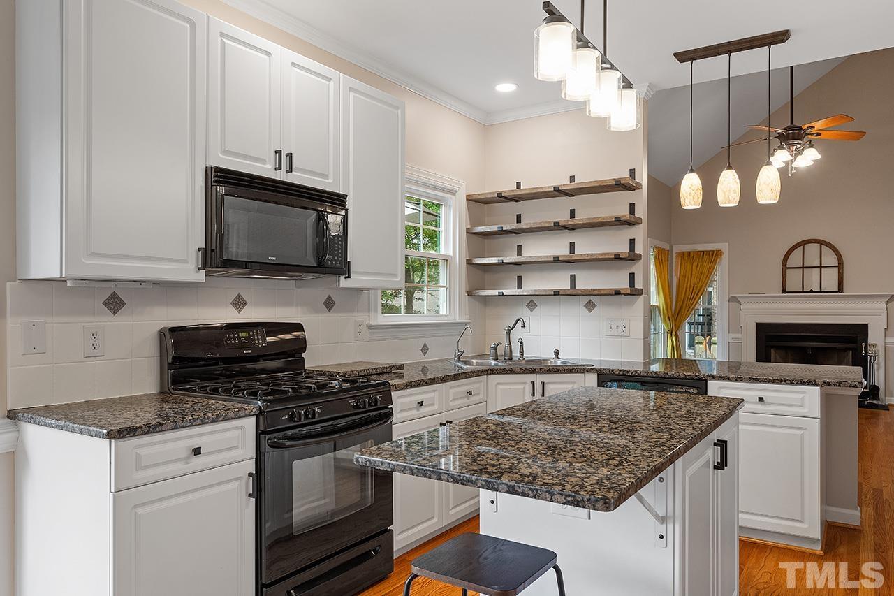 403 Danton Drive Cary, NC 27518 - Photo 3 of 38 a kitchen with stainless steel appliances granite countertop a sink a stove and a microwave