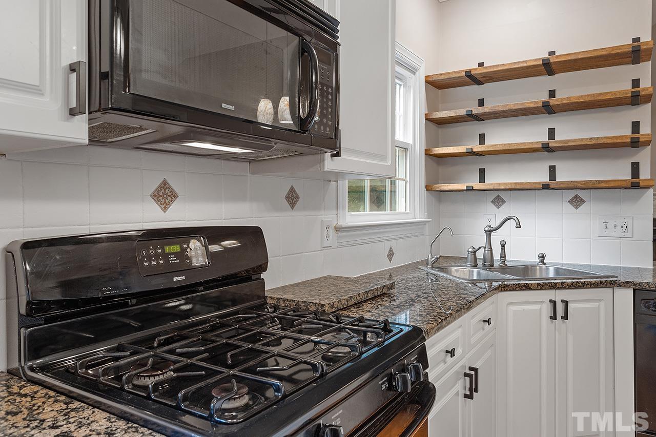 403 Danton Drive Cary, NC 27518 - Photo 7 of 38 a kitchen with granite countertop a stove and a sink