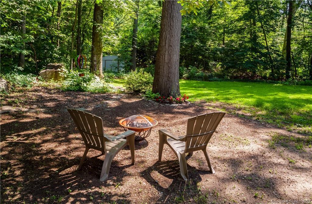 318 Romanock Road Fairfield, CT 06825 - Photo 1 of 1 a view of a backyard with table and chairs potted plants and large tree