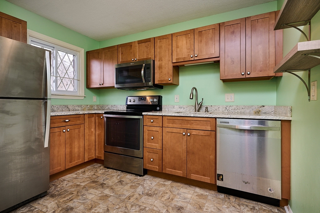 170 East Hadley Road, Unit 124 Amherst, MA 01002 - Photo 3 of 20 a kitchen with stainless steel appliances granite countertop a refrigerator sink and cabinets