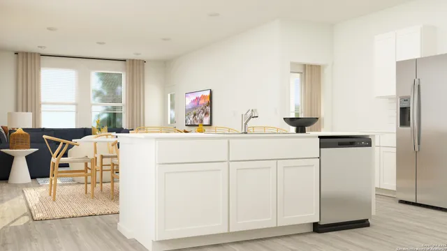 a kitchen with white cabinets and sink