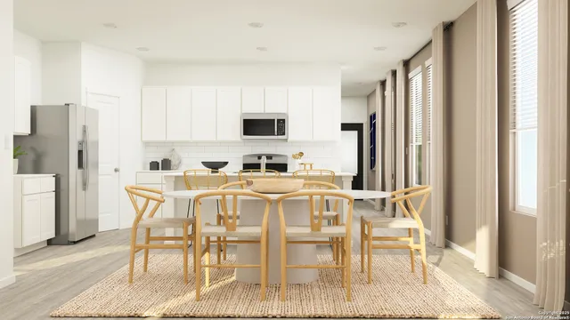 a kitchen with stainless steel appliances granite countertop a dining table chairs refrigerator and a window