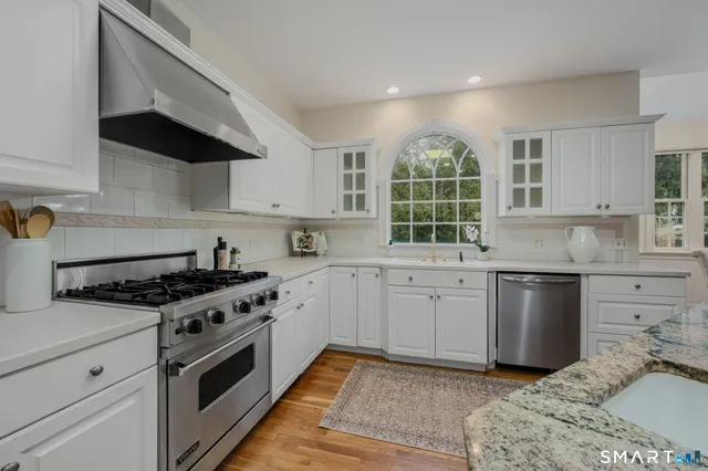 a kitchen with a stove a sink and a window