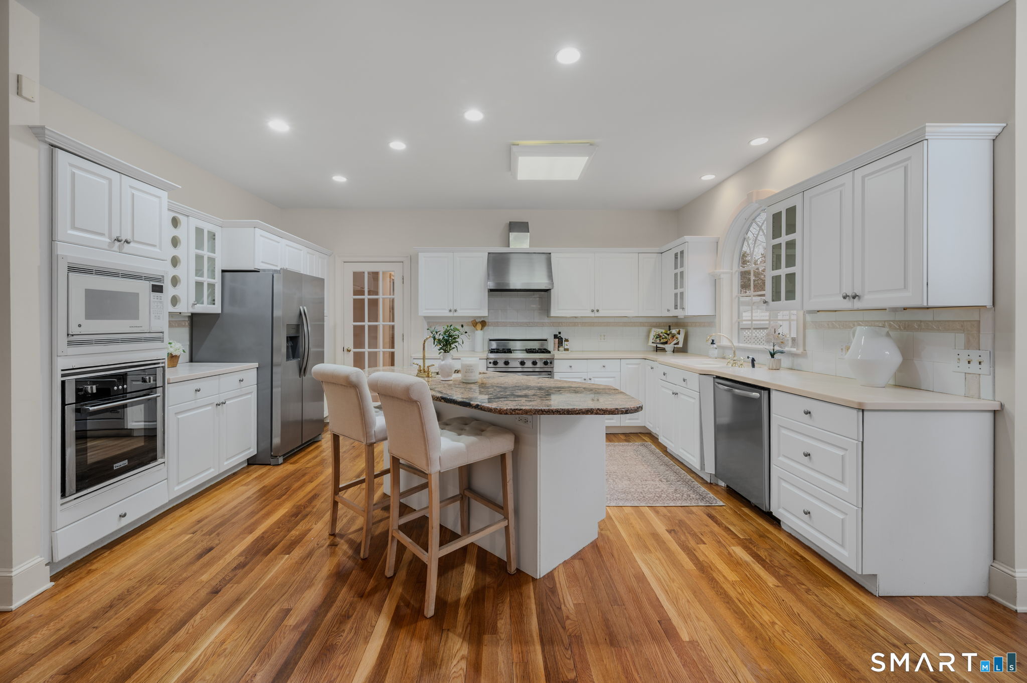 14 Riverside Drive Waterford, CT 06385 - Photo 13 of 40 a kitchen with stainless steel appliances a stove a sink dishwasher a refrigerator with white cabinets and wooden floor