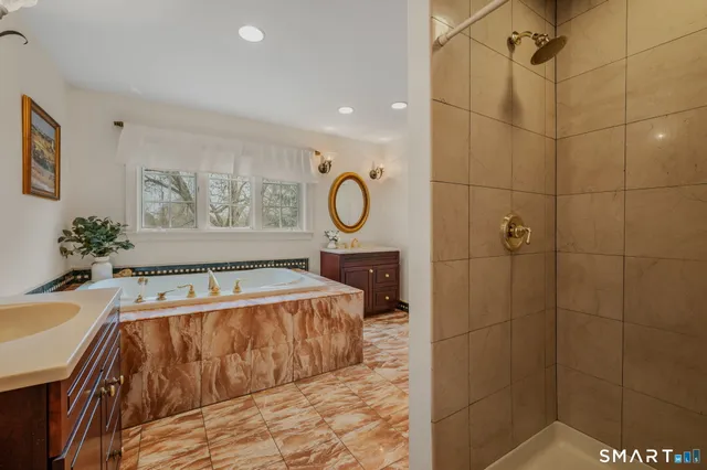 a bathroom with a tub a window and a shower