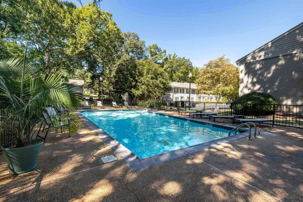 a view of a swimming pool with a patio and a yard