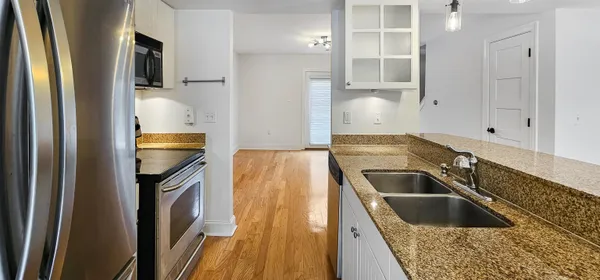 a kitchen with granite countertop a sink and a refrigerator