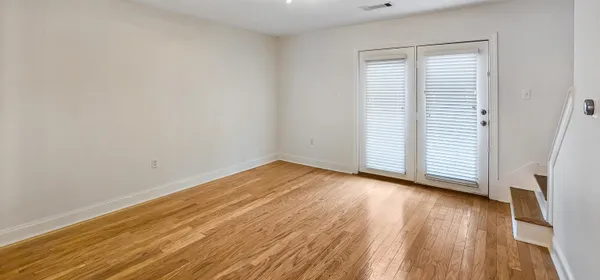 a view of a room with wooden floor and a window