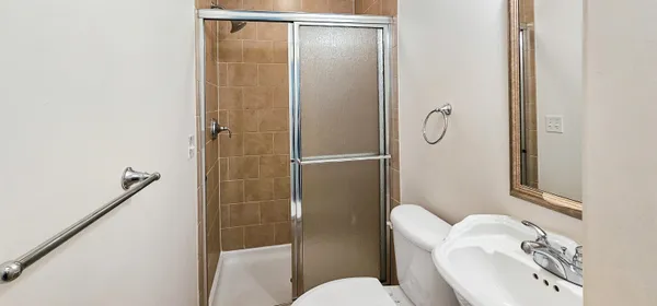 a bathroom with a sink a toilet and shower