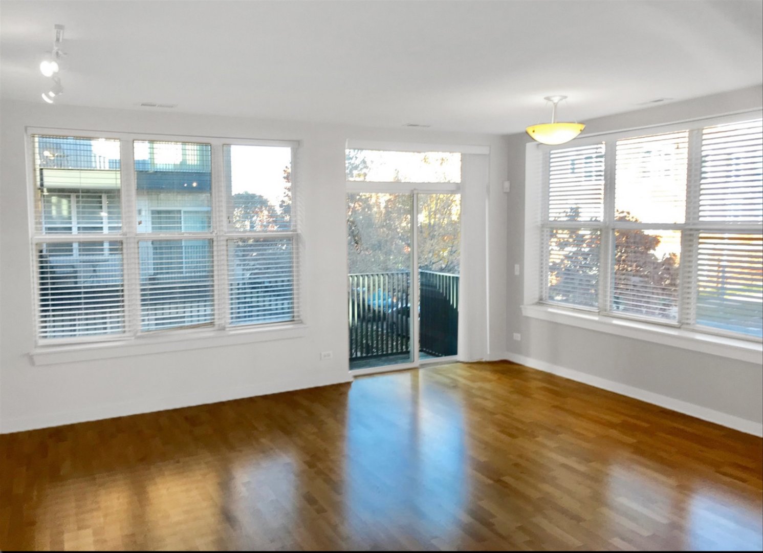 2231 West Maypole Avenue, Unit 201 Chicago, IL 60612 - Photo 3 of 10 a view of an empty room with wooden floor and a window