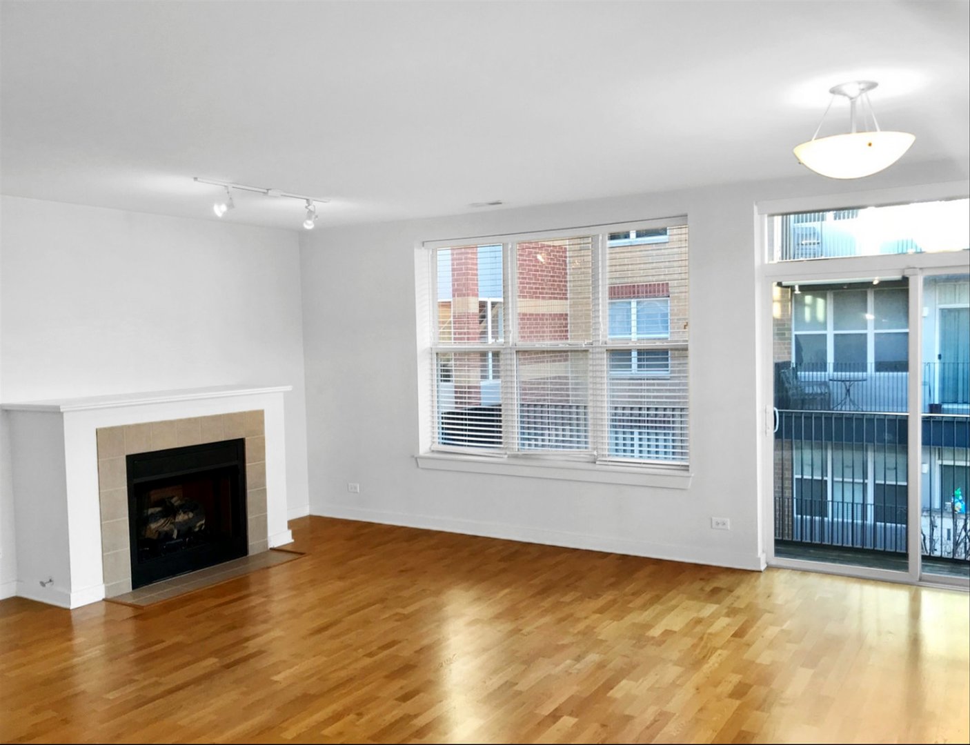 2231 West Maypole Avenue, Unit 201 Chicago, IL 60612 - Photo 4 of 10 a view of an empty room with a window and fireplace