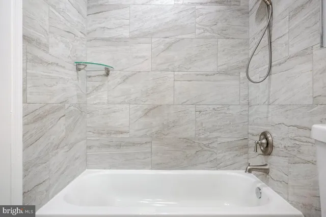 a bathroom with a bath tub with a shower