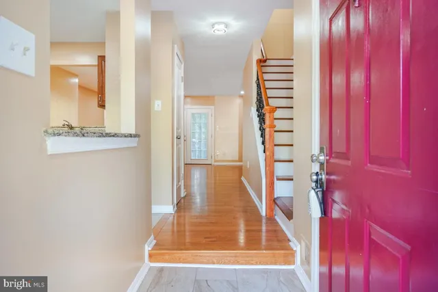 a view of a hallway with wooden floor and windows
