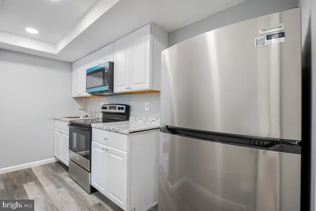 a kitchen with a refrigerator and a stove top oven