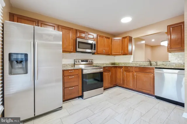 a kitchen with stainless steel appliances granite countertop a refrigerator sink and cabinets