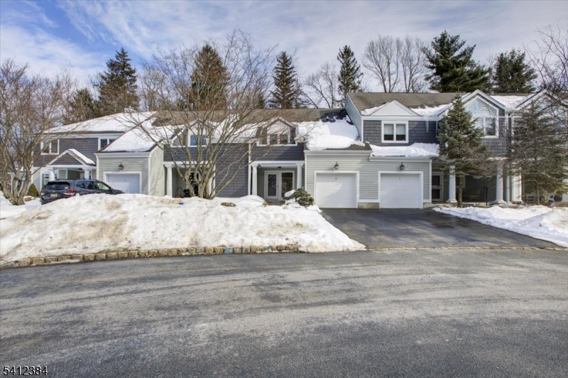 a view of residential houses with snow on the road