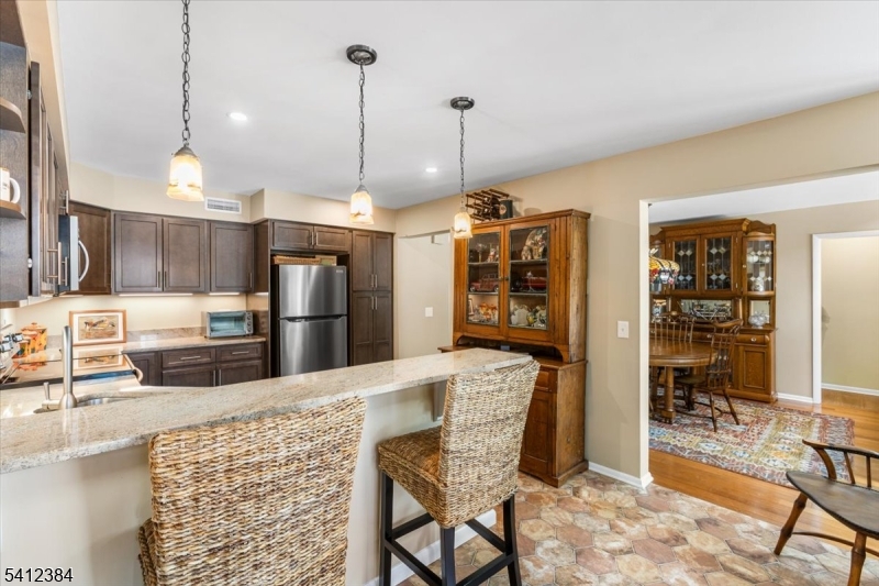 10 Gristmill Sparta, NJ 07871 - Photo 14 of 35 a kitchen with stainless steel appliances kitchen island granite countertop a refrigerator a stove a sink with island and chairs