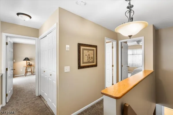 a view of a hallway with a livingroom and a chandelier
