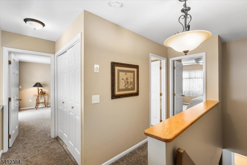 10 Gristmill Sparta, NJ 07871 - Photo 20 of 35 a view of a hallway with a livingroom and a chandelier