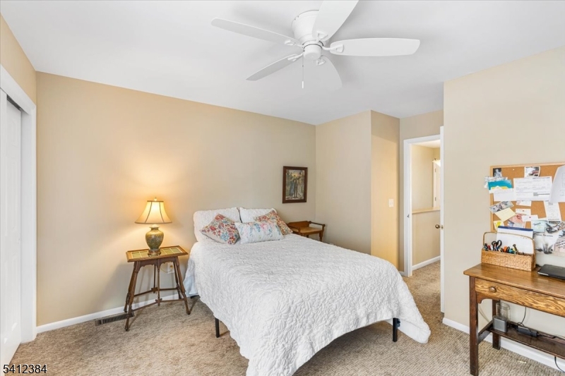 10 Gristmill Sparta, NJ 07871 - Photo 29 of 35 a bedroom with a bed a table and chair