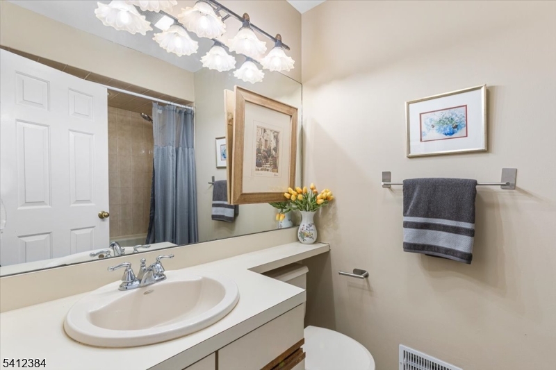 10 Gristmill Sparta, NJ 07871 - Photo 30 of 35 a bathroom with a sink a mirror and a toilet