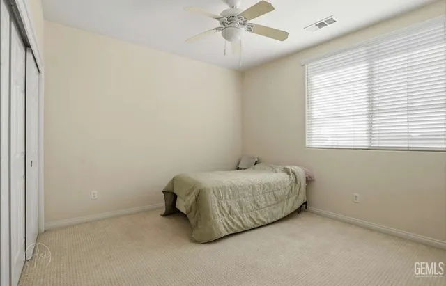 a room with a bed and ceiling fan