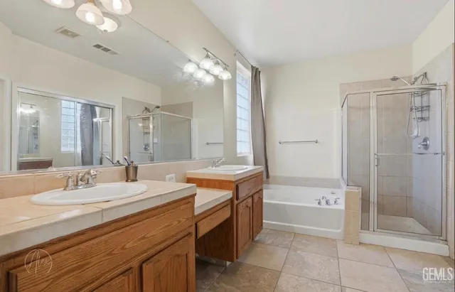 a bathroom with a double vanity sink mirror and shower