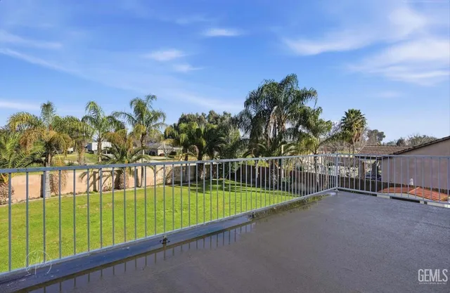 a view of a swimming pool with a bench and trees around