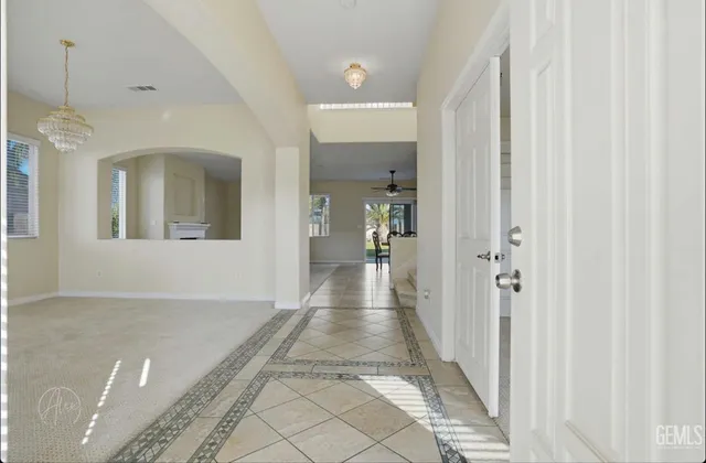 a view of a hallway with wooden floor and a living room