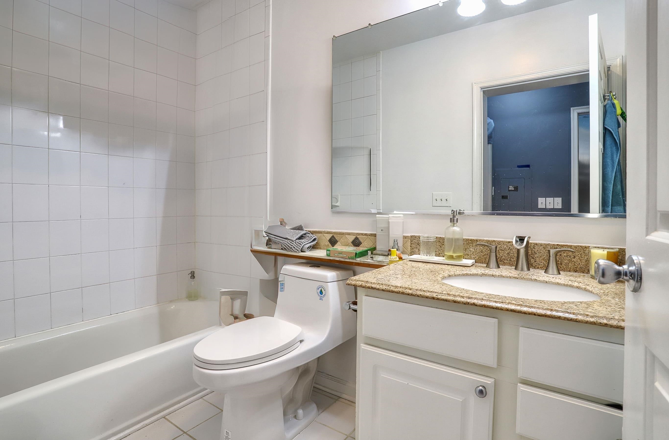 340 The Promenade, Unit 340 Edgewater, NJ 07020 - Photo 16 of 20 a bathroom with a granite countertop toilet sink and mirror