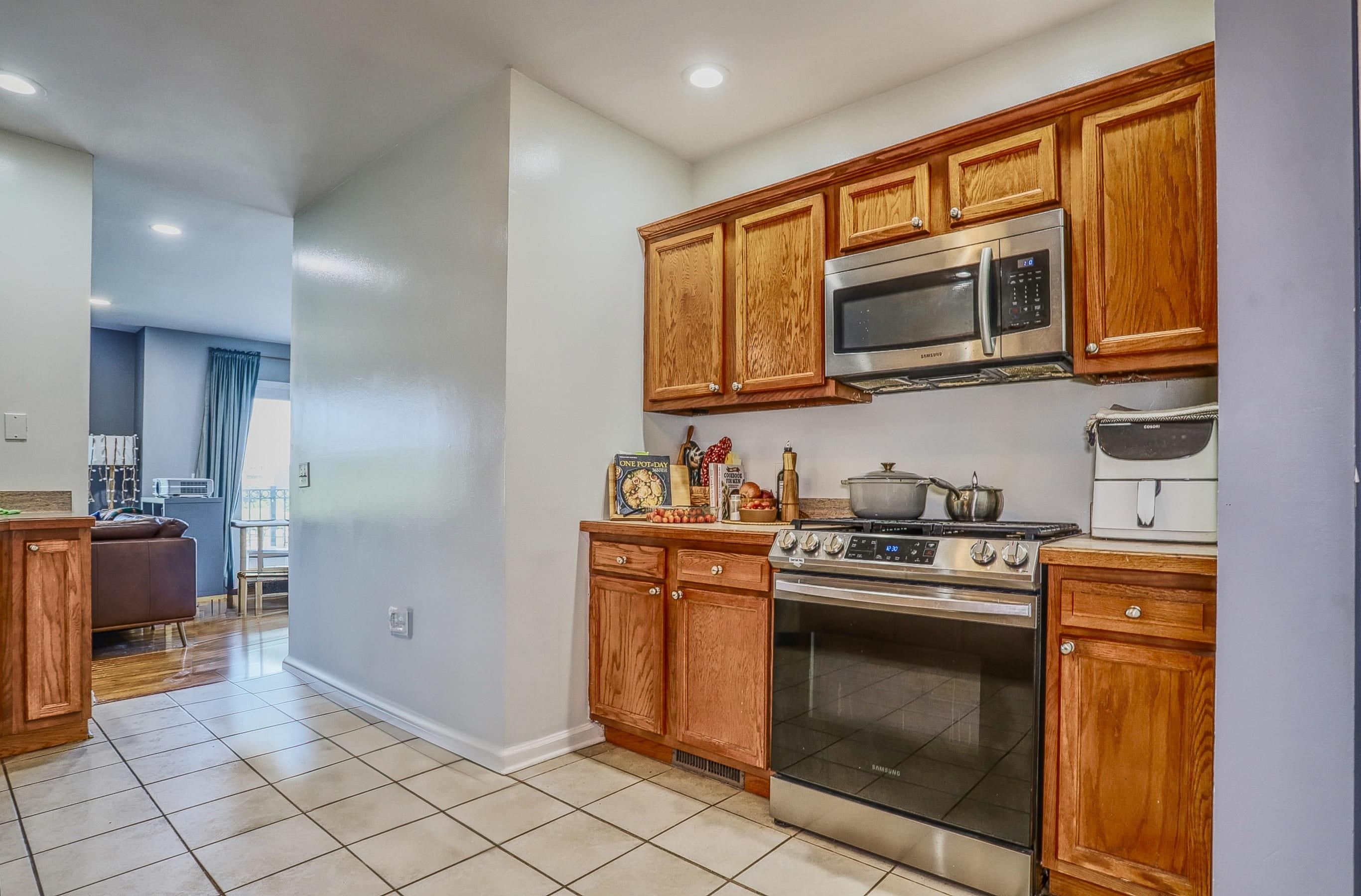340 The Promenade, Unit 340 Edgewater, NJ 07020 - Photo 10 of 20 a kitchen with stainless steel appliances granite countertop a stove a sink and a microwave
