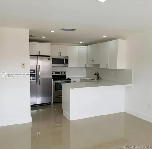 a kitchen with stainless steel appliances granite countertop a refrigerator and a stove