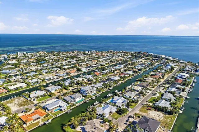 a living room with furniture large windows and a view of kitchen
