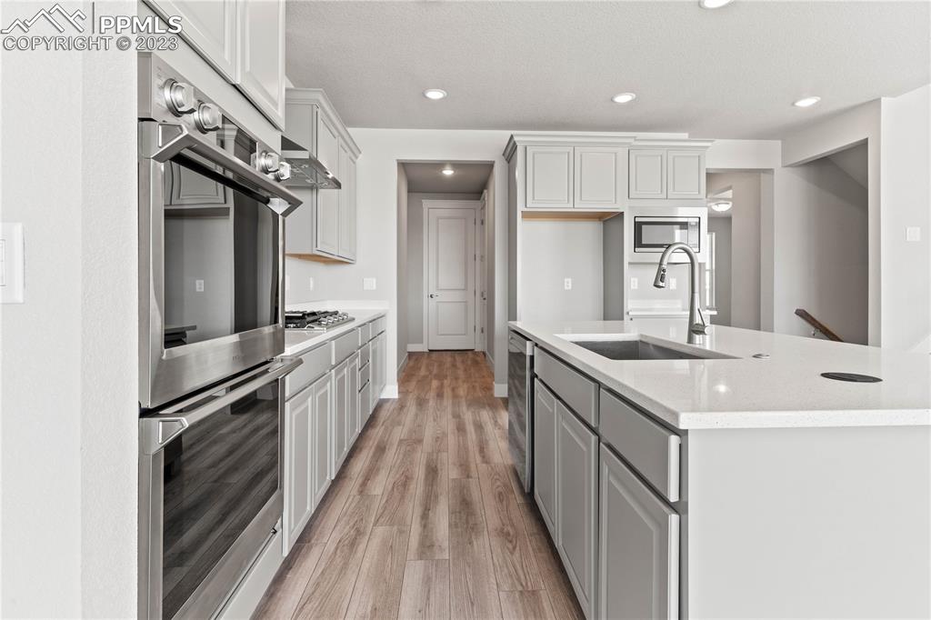 2155 Coyote Mint Drive Monument, CO 80132 - Photo 14 of 45 a kitchen with kitchen island granite countertop a sink and stainless steel appliances