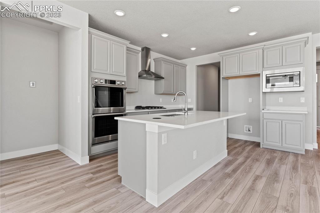 2155 Coyote Mint Drive Monument, CO 80132 - Photo 15 of 45 a kitchen with white cabinets and stainless steel appliances